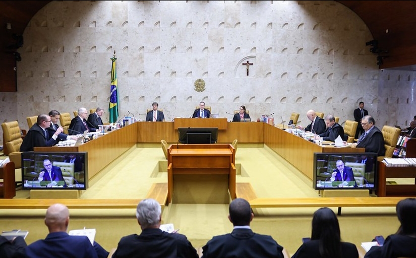 Plenário do Supremo Tribunal Federal. 11 ministros dispostos em uma grande mesa em formato de U. Ao fundo, a bandeira do Brasil, o brasão da Justiça e um crucifixo