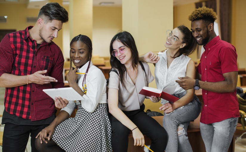 estudantes conversando com livros na mão
