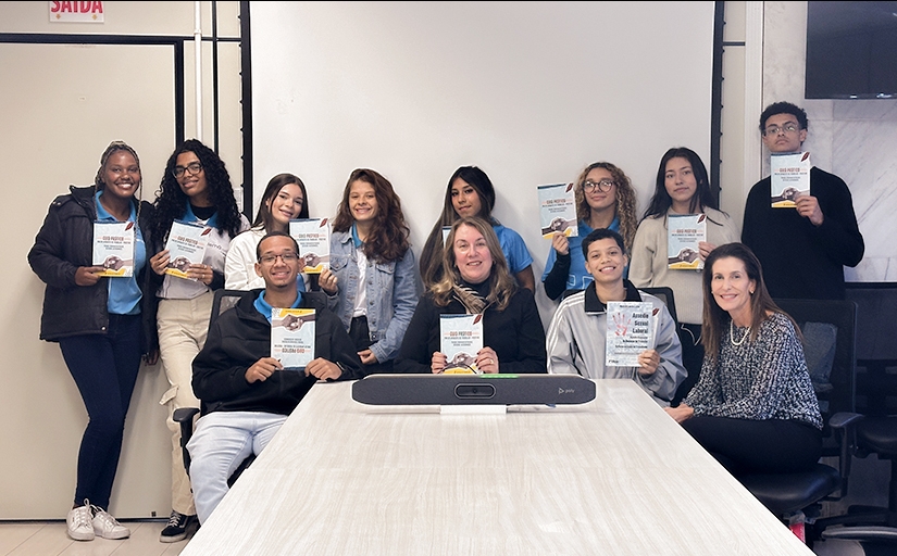 Jovens segurando cartilha sobre assédio moral