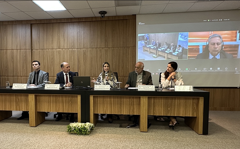 Cinco pessoas sentadas em uma mesa de palestras
