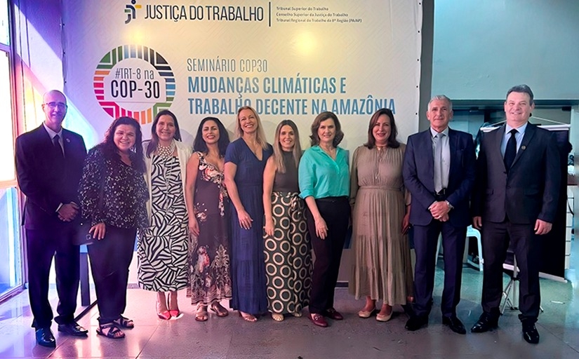 Fotografia com 3 homens e 7 mulheres vestidos formalmente e sorrindo para a câmera