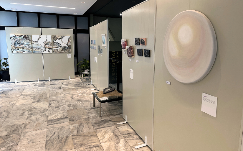 Foto de uma exposição com obras de arte expostas em painéis