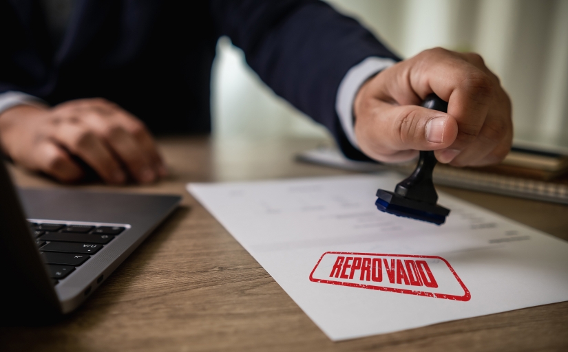 Arte ilustrativa de uma folha de papel sendo carimbada com a palavra "reprovado"