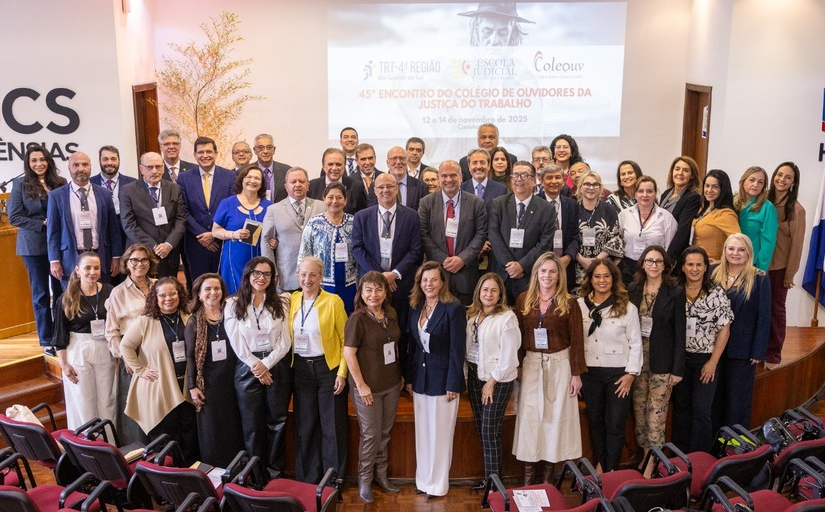 Grupo grande de participantes posa sorrindo em auditório durante o 45º Encontro do Coleouv
