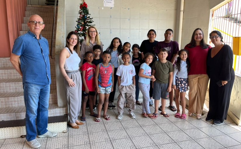 Grupo de crianças com alguns adultos posam para a foto