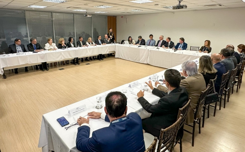 Cerca de 30 autoridades reunidas em uma mesa em formato de U