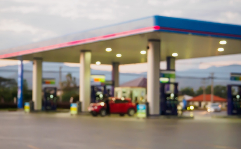 Fotografia ilustrativa com pouca nitidez de um posto de gasolina com movimento durante o dia