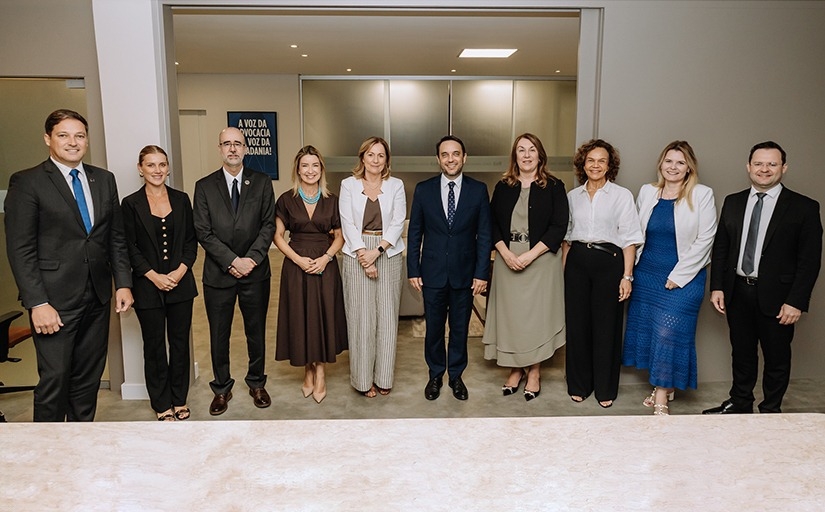 Grupo de dez pessoas posa para foto.