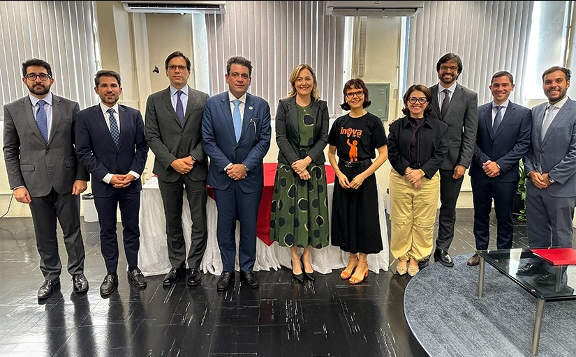 Sete homens de terno e gravata e três mulheres estão em pé posando para a foto