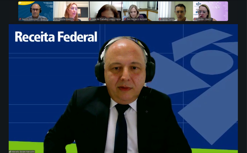 Print de tela de um homem grisalho de terno e gravata fazendo uma palestra por videoconferência