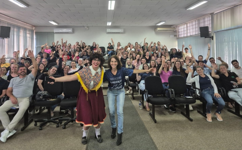 Foto de um auditório cheio de trabalhadores homens e mulheres celebrando.