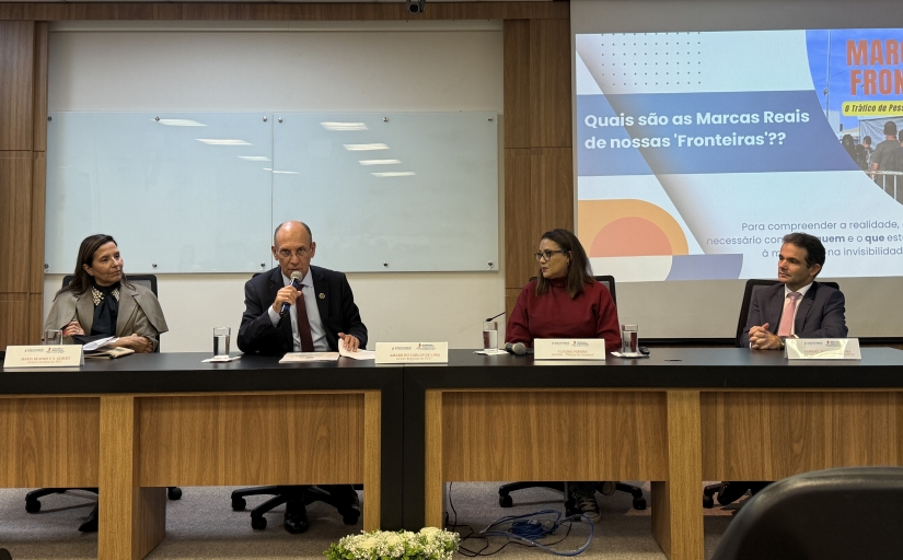 Dois homens e duas mulheres sentados à mesa de um evento
