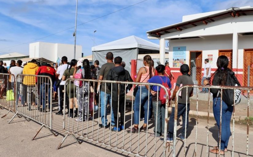 Imagem mostra uma fila de pessoas no que parece ser um posto de imigração