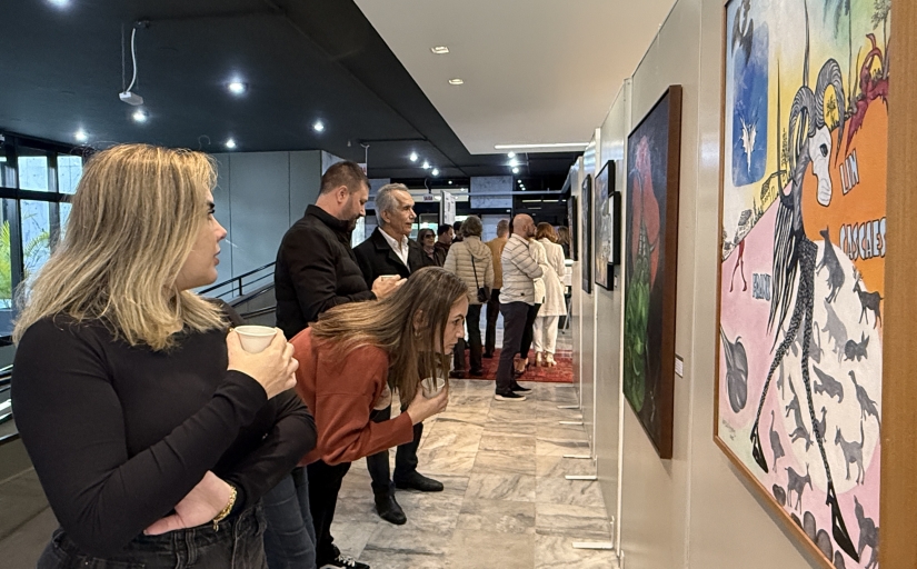 Grupo de oito pessoas observando telas de Franklin Cascaes