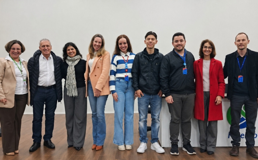 Cinco mulheres e quatro homens estão lado a lado posando para a foto