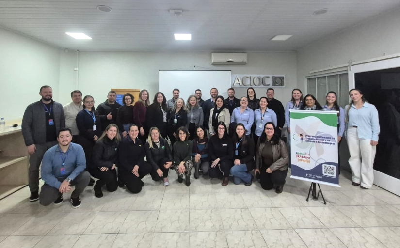 Grupo de 30 pessoas reunidas posam para foto na sede da ACIOC