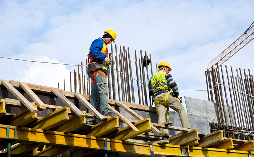 Homens com apetrechos de operário da construção civil
