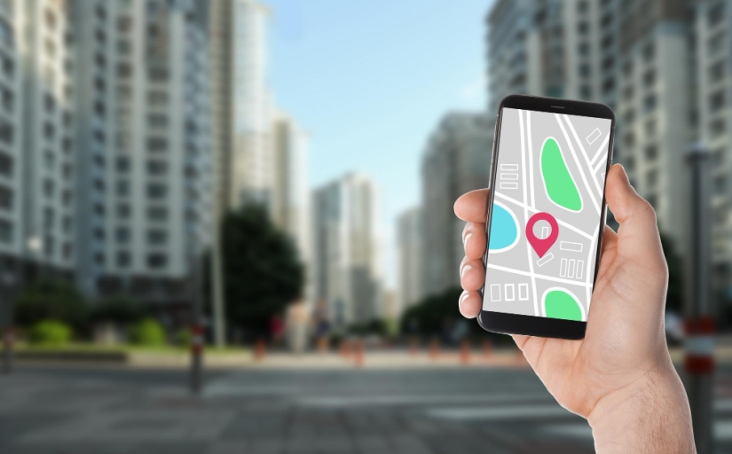 Mão segura um celular com a imagem do Google Street View com imagens distorcidas de prédios ao fundo
