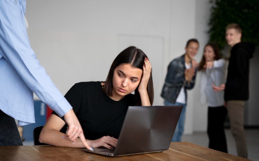 Homem humilha mulher no ambiente de trabalho, em uma cena que é observada pelos colegas