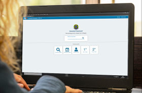 Pessoa está em frente a uma tela de computador com a página do Processo Judicial Eeltrônico aberta