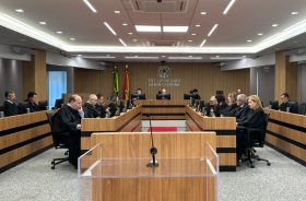 Fotografia da sala de sessões do pleno. Sentados, diante de microfones e telas de computadores, homens e mulheres de toga estão concentrados.
