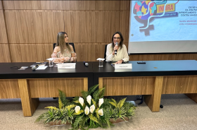 Foto de duas mulheres sentadas fazendo uma palestra
