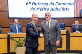 Dois homens de terno se cumprimentam e posam para foto. 