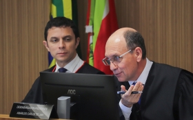 Homem sentado em mesa falando no microfone