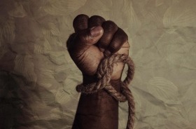 Foto da mão de um negro segurando uma corda