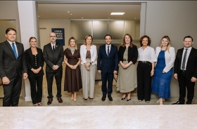 Grupo de dez pessoas posa para foto.