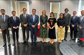 Sete homens de terno e gravata e três mulheres estão em pé posando para a foto