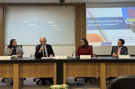 Dois homens e duas mulheres sentados à mesa de um evento