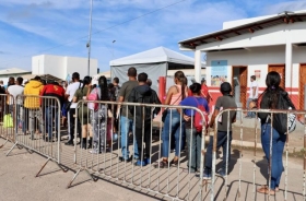 Imagem mostra uma fila de pessoas no que parece ser um posto de imigração