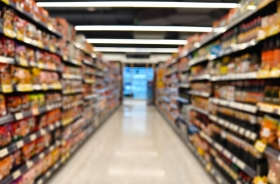 Fotografia ilustrativa de um corredor de supermercado, com os produtos à mostra nas gôndolas