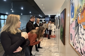 Grupo de oito pessoas observando telas de Franklin Cascaes