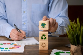 Foto de um homem empilhando cubos com imagens sobre sustentabilidade