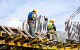 Homens com apetrechos de operário da construção civil