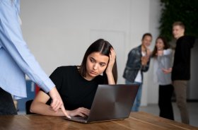 Homem humilha mulher no ambiente de trabalho, em uma cena que é observada pelos colegas