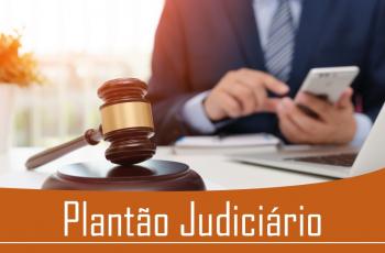 Homem de terno, em segundo plano, mexe no que parece ser um celular. Em primeiro plano, o martelo da Justiça e o texto Plantão Judiciário 