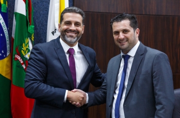 Dois homens de terno dando as mãos em cumprimento