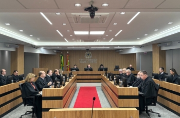 Fotografia da sessão do pleno em que a tese jurídica foi aprovada.  Homens e mulheres estão sentados diante de computadores, vestindo togas.