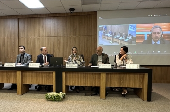 Cinco pessoas sentadas em uma mesa de palestras