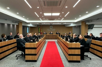 Fotografia do plenário do TRT-SC com magistrados sentados em U, diante da mesa da Presidência, e tapete vermelho ao centro