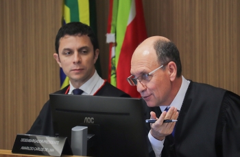 Homem sentado em mesa falando no microfone
