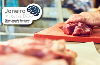 Foto mostra duas bandejas com carne sendo manipulada pelas mãos de um açougueiro. No canto superior esquerdo, o texto Janeiro Branco, mês da conscientização da saúde mental