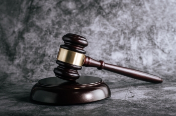 Foto do martelo da Justiça com um fundo cinza