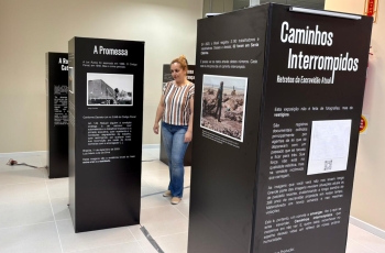 Mulher ruiva observa totens de uma exposição.