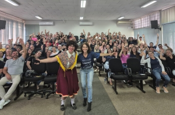 Foto de um auditório cheio de trabalhadores homens e mulheres celebrando.