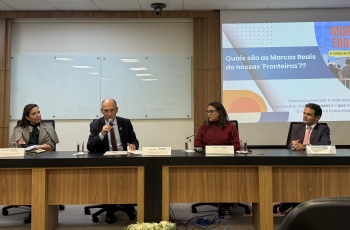 Dois homens e duas mulheres sentados à mesa de um evento