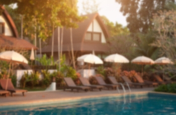 Fotografia ilustrativa de um local desfocado com árvores e piscina